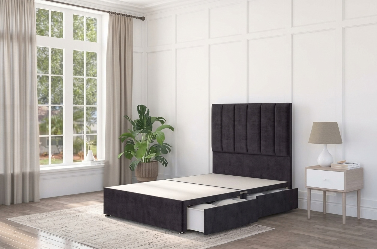 A black divan bed base in a modern interior with panelled headboard in a black velvet material. 
